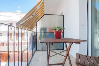 a potted plant sitting on a wooden table on a balcony at Hola! - Sitges Centric Apartment in Sitges