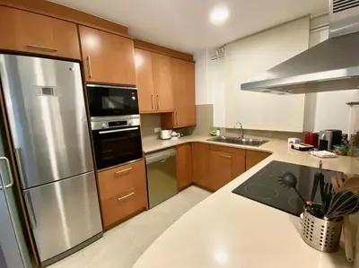 a kitchen with wooden cabinets and a stainless steel refrigerator at Centric and spacious, excellent for families in Barcelona