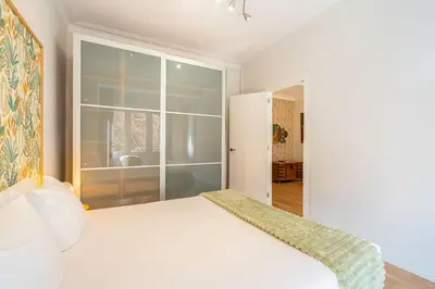 a bedroom with a white bed and a large window at Barcelona Eixample in Barcelona
