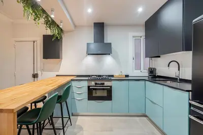a kitchen with blue cabinets and a wooden counter top at Barcelona Eixample in Barcelona