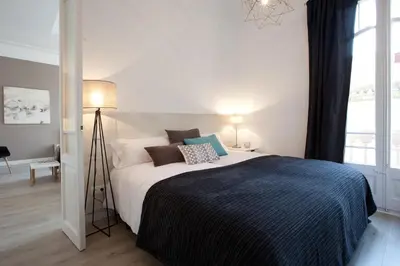 a bedroom with a bed and a large window at Click&Flat Seneca Suites in Barcelona