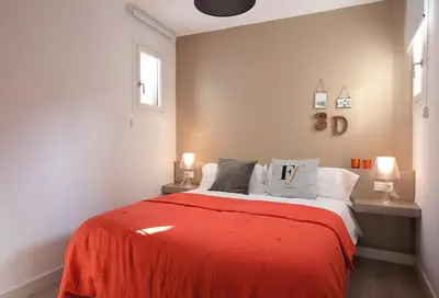 a bedroom with a bed with red blanket and pillows at Click&Flat Seneca Suites in Barcelona