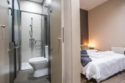 a bathroom with a bed and a shower and a toilet at Tendency Apartments 9 in Barcelona