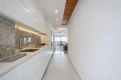 a kitchen with white counters and a long hallway at Apartment Marti in Barcelona