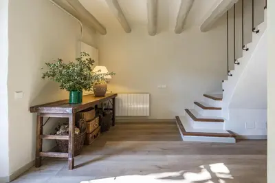 a hallway with stairs and a table with a plant on it at Finca Can Romeu: alojamiento rural entre viñedos in Font-Rubí