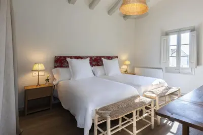 a bedroom with a large white bed and a window at Finca Can Romeu: alojamiento rural entre viñedos in Font-Rubí
