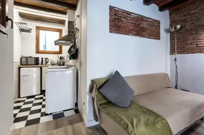 a living room with a couch and a kitchen at Apartamento La Boqueria 4 in Barcelona
