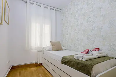 a small bedroom with a bed with towels on it at Alcam Gold in Barcelona