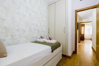 a bedroom with two beds and a wall with floral wallpaper at Alcam Gold in Barcelona