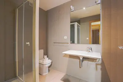 a bathroom with a sink and a toilet and a mirror at Alcam Gold in Barcelona