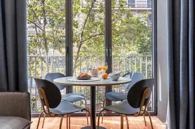 a table and chairs in a room with a large window at Aspasios Diagonal Art Apartments in Barcelona