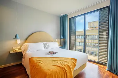 a bedroom with a large bed and a large window at Aspasios Diagonal Art Apartments in Barcelona