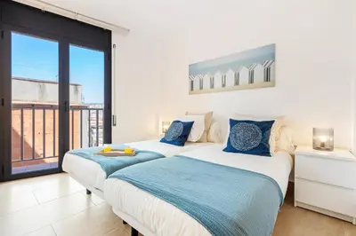 two beds in a room with a large window at AB Besòs River Apartment in Sant Adria de Besos