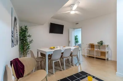 a dining room with a white table and chairs at AB Besòs River Apartment in Sant Adria de Besos
