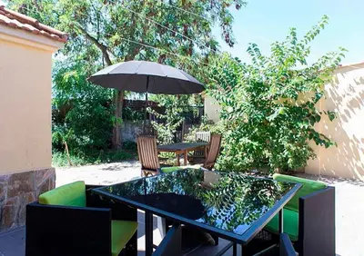 a table and chairs with an umbrella on a patio at Tu Casa en Barcelona in Sant Cugat del Vallès