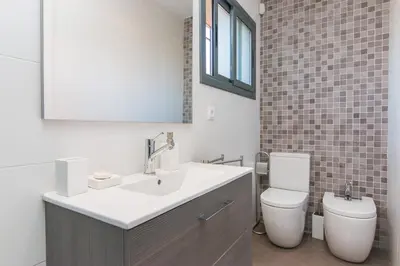 a bathroom with a sink and a toilet and a mirror at Tu Casa en Barcelona in Sant Cugat del Vallès