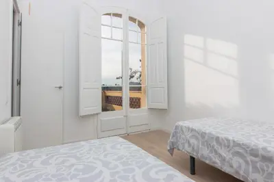a white room with a bed and a window at Tu Casa en Barcelona in Sant Cugat del Vallès