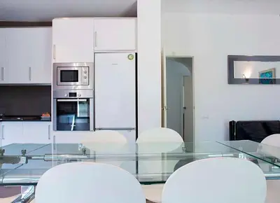 a kitchen with a glass table and white appliances at Tu Casa en Barcelona in Sant Cugat del Vallès