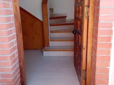 an empty hallway with an open door and stairs at Casa en Castelldefels a 5 min de la playa in Castelldefels