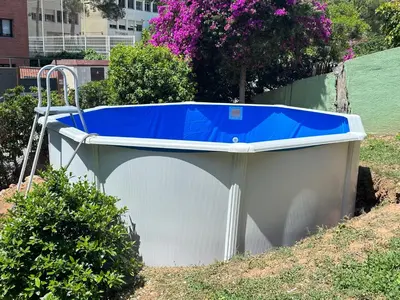 a bath tub with a blue top sitting in the grass at Casa en Castelldefels a 5 min de la playa in Castelldefels