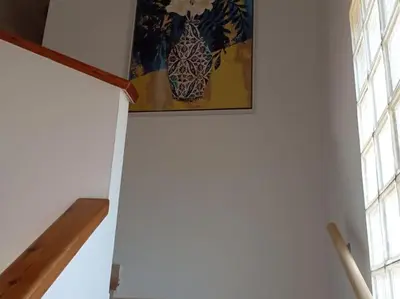 a painting hanging on a ceiling in a room with windows at Casa en Castelldefels a 5 min de la playa in Castelldefels