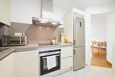 a kitchen with white cabinets and a stainless steel refrigerator at Les Corts Exclusive Apartments by Olala Homes in Barcelona