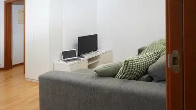 a living room with a couch and a tv at MarBarcelona Suites Berlin in Barcelona