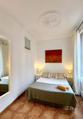 a bedroom with a bed and a mirror at Cozy Ploblesec Apartment in Barcelona