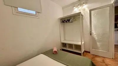 a bedroom with a bed and a painting on the wall at Cozy Ploblesec Apartment in Barcelona