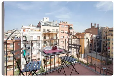a table and chairs on a balcony with buildings at Piquer con Terraza in Barcelona