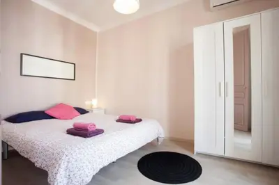 a bedroom with a bed with pink pillows on it at Piquer con Terraza in Barcelona