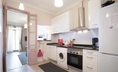 a kitchen with white cabinets and a washer at Piquer con Terraza in Barcelona