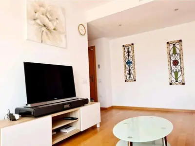 a living room with a tv and a table at MERCE APARTMENT FORUM BARCELONA in Sant Adria de Besos