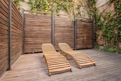 two chairs and a fence on a wooden deck at Sweett - Casa Girona in Barcelona
