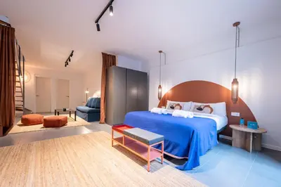 a bedroom with a large blue bed and a couch at Sweett - Casa Girona in Barcelona