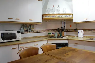 a kitchen with white cabinets and a table and a microwave at Quiet apartment! Sagrada Familia! in Barcelona