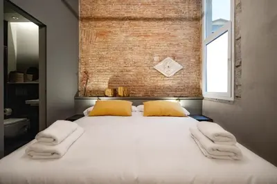a bedroom with a large bed with towels on it at Hostal Porxos Garden in Barcelona
