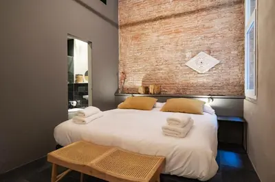 a bedroom with a bed with towels on it at Hostal Porxos Garden in Barcelona