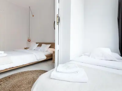 two beds in a room with white sheets and towels at Bruc & Bruc in Barcelona