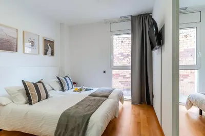 two beds in a white room with two windows at 4207 - AB Sant Adria de Besos in Sant Adria de Besos