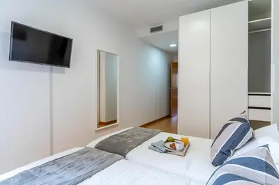 a bedroom with a white bed and a flat screen tv at 4207 - AB Sant Adria de Besos in Sant Adria de Besos