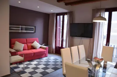 a living room with a red couch and a table at Autèntic Eixample Barcelona in Barcelona