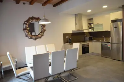 a kitchen with white chairs and a mirror on the wall at Autèntic Eixample Barcelona in Barcelona