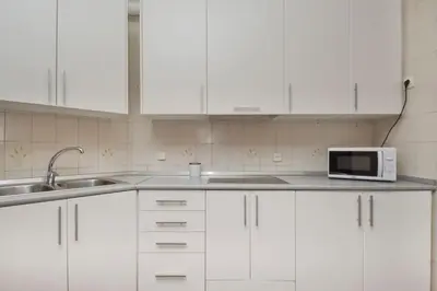 a white kitchen with a sink and a microwave at Autèntic Barcelona Monumental in Barcelona