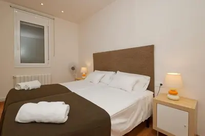 a bedroom with a large bed with two towels on it at Autèntic Barcelona Monumental in Barcelona