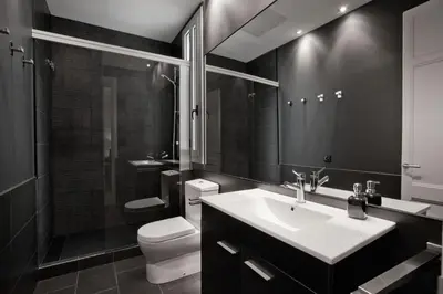 a black and white bathroom with a sink and a toilet at Casanova Charm 4BDR Apartment in Barcelona