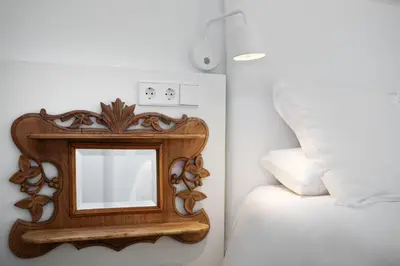 a mirror on a wall next to a bed at Casanova Charm 4BDR Apartment in Barcelona