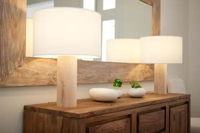 a mirror and two white vases on a wooden table at Casanova Charm 4BDR Apartment in Barcelona