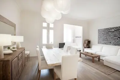 a white living room with a table and a white couch at Casanova Charm 4BDR Apartment in Barcelona