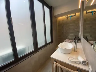 a bathroom with a sink and large windows at Spatious luxe apartment Paseo de Gracia Diagonal in Barcelona